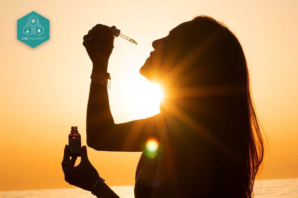 Person using CBD oil sublingually under the tongue.